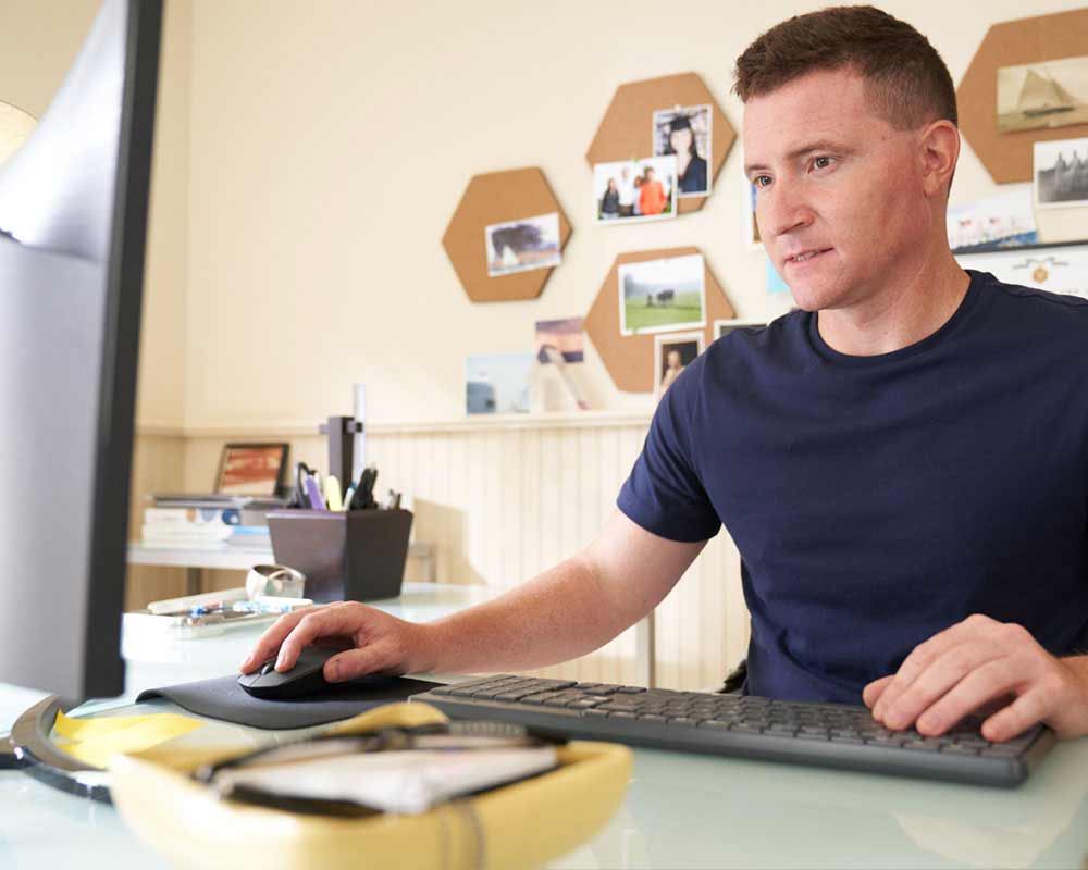 A person typing on a keyboard and using a mouse.