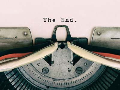 Close up of a vintage typewriter with the words "The End." typed on the paper.
