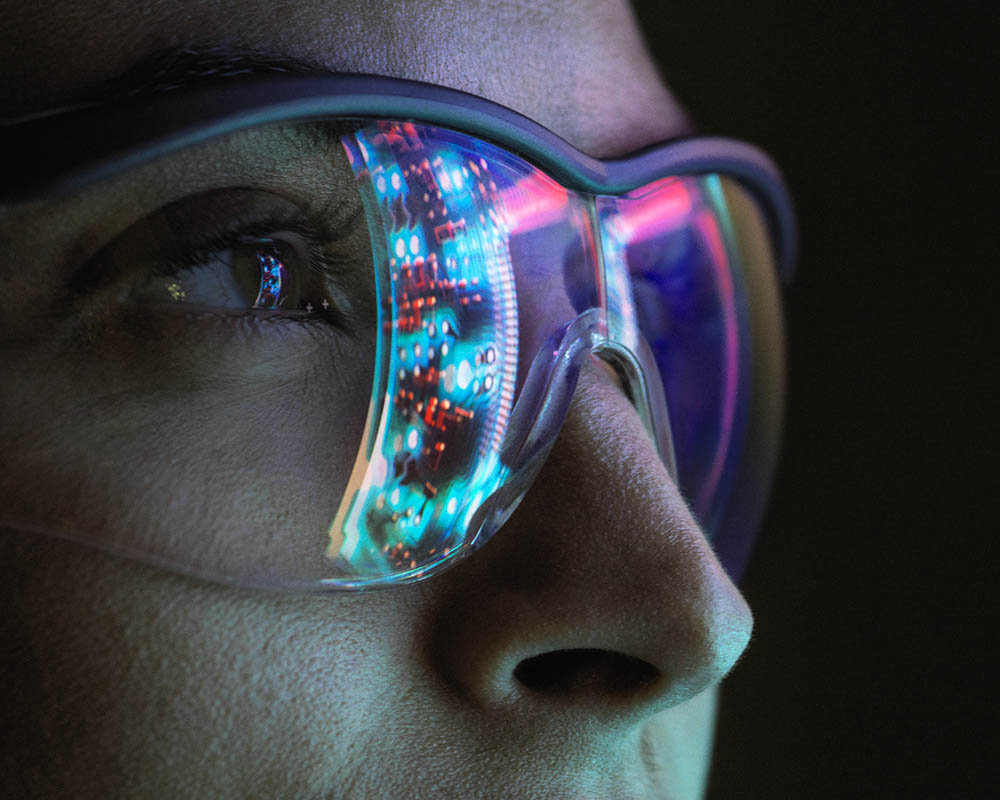 A person wearing eyeglasses with an abstract image depicted on one lens.