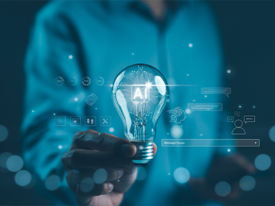 A person holding a light bulb with "AI" lit up inside of it..
