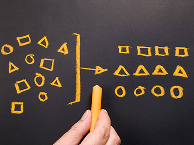 A chalk drawing depicting the act of grouping similar shapes together.