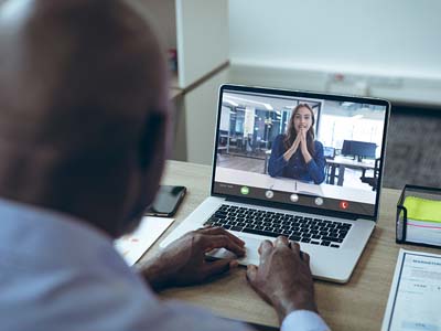 Two people engaging in a video call on a laptop.