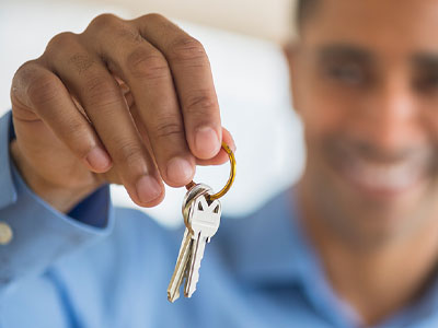 Man holding up two keys on a key ring