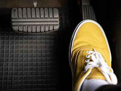 A person's foot on the gas pedal of a vehicle.