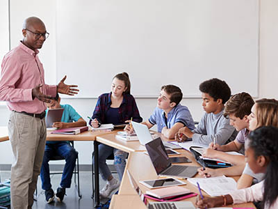 A person addressing a classroom of students.