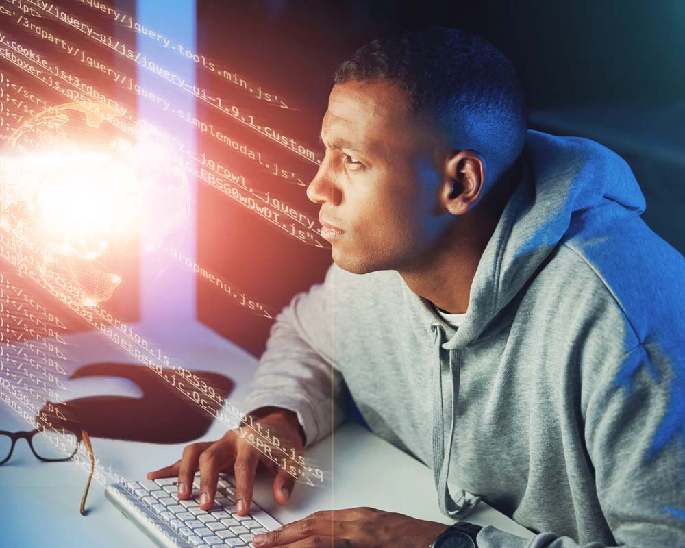 A person typing on a keyboard with lines of code reflected in the light.