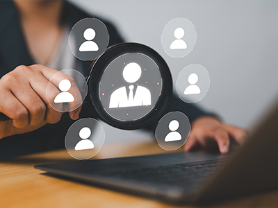 Icons hovering over a laptop, and a person in the background is pointing to the icons.