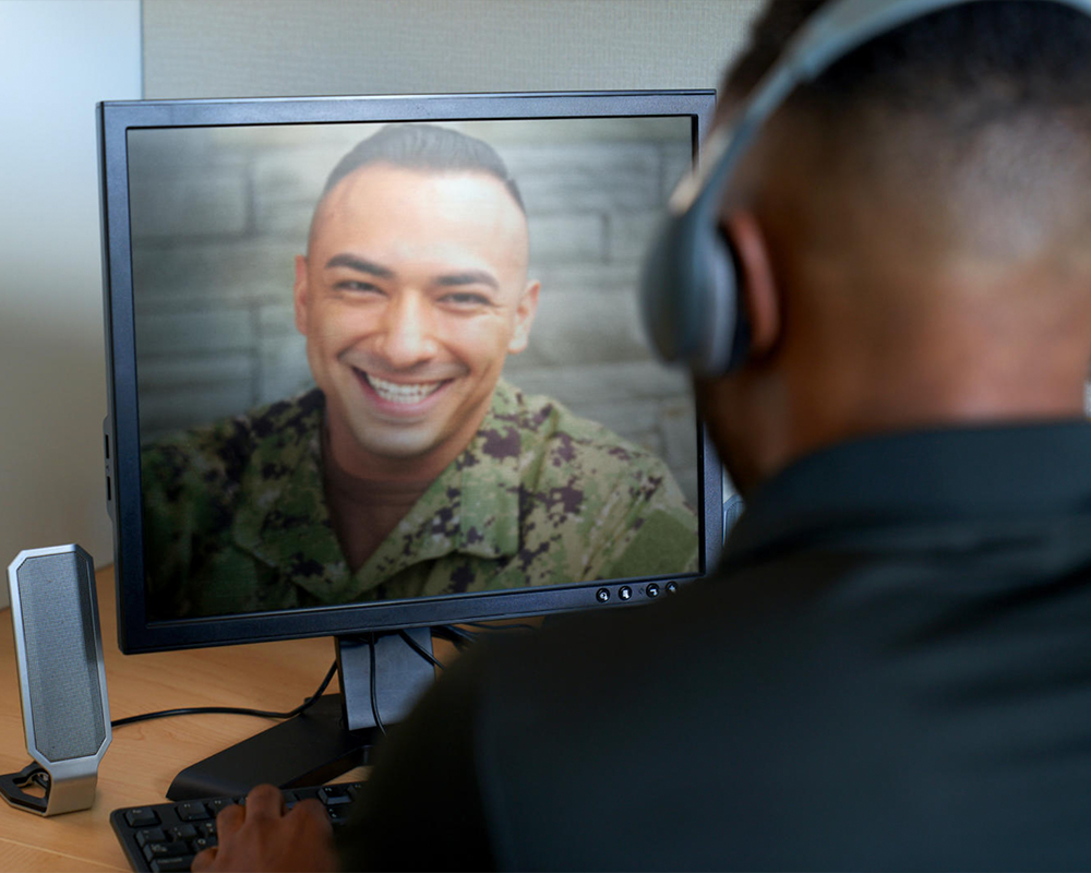 Two people, one in a military uniform, on a video conference call.