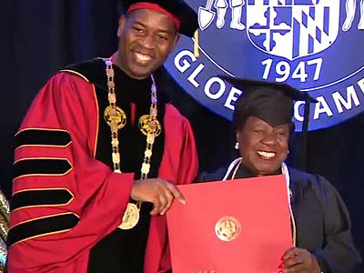 UMGC President Gregory W. Fowler giving a diploma to a graduate.