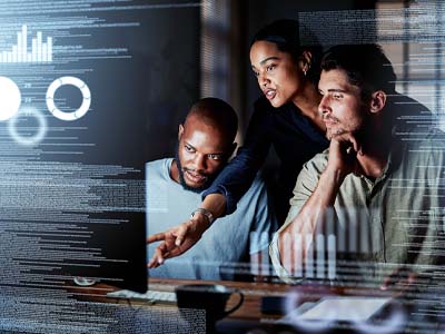 Three people looking at a computer monitor.