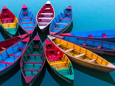 Different colored boats gathered together in water.
