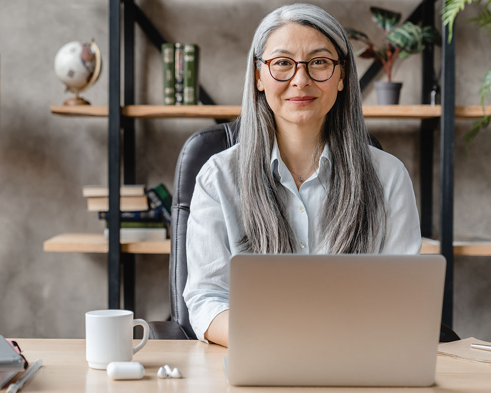 A person typing on a laptop and smiling.