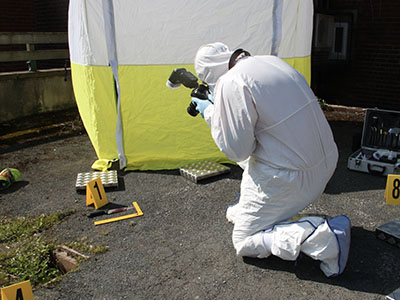 A person in a hazmat suit taking a photograph.