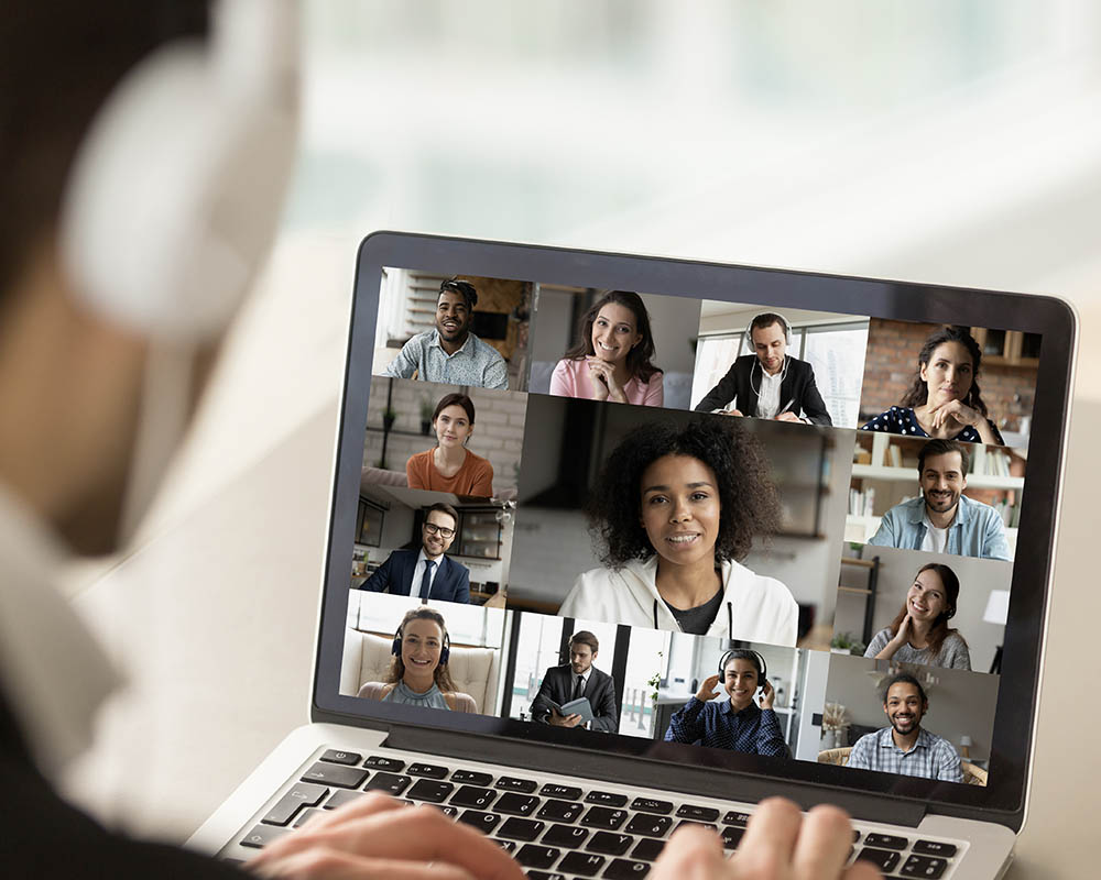 A person looking at a video conference call on a laptop.