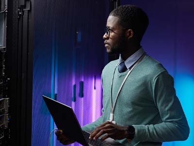 A person standing and holding a laptop.