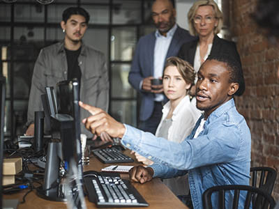 Five people looking at a computer monitor.