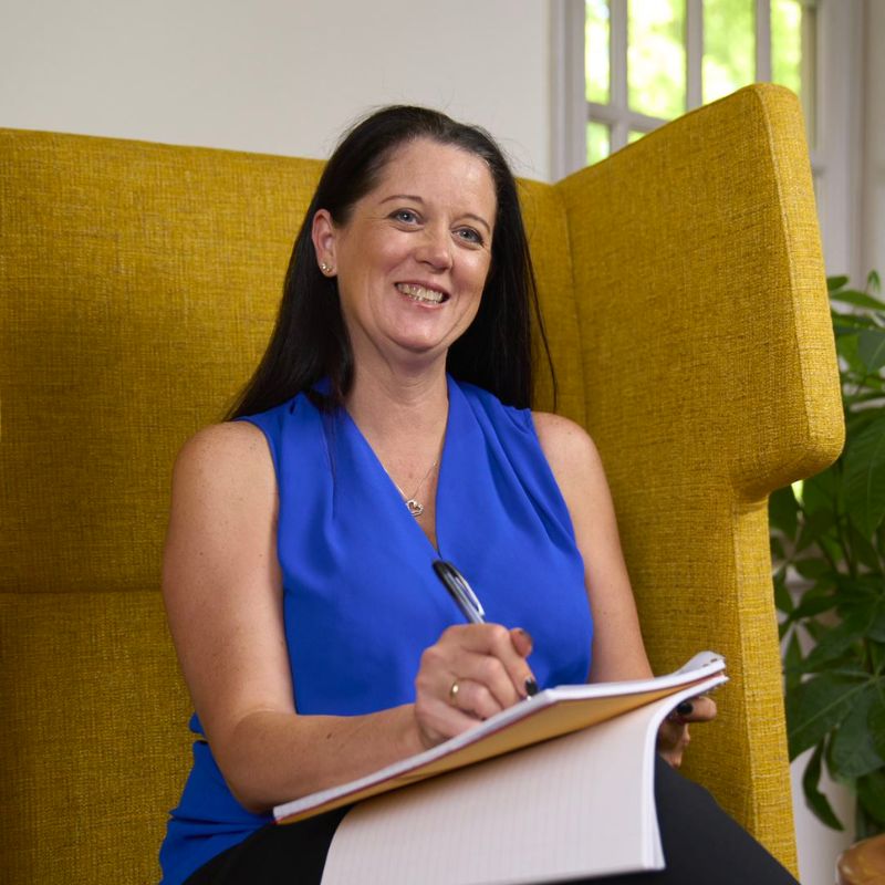 A person taking notes and smiling.