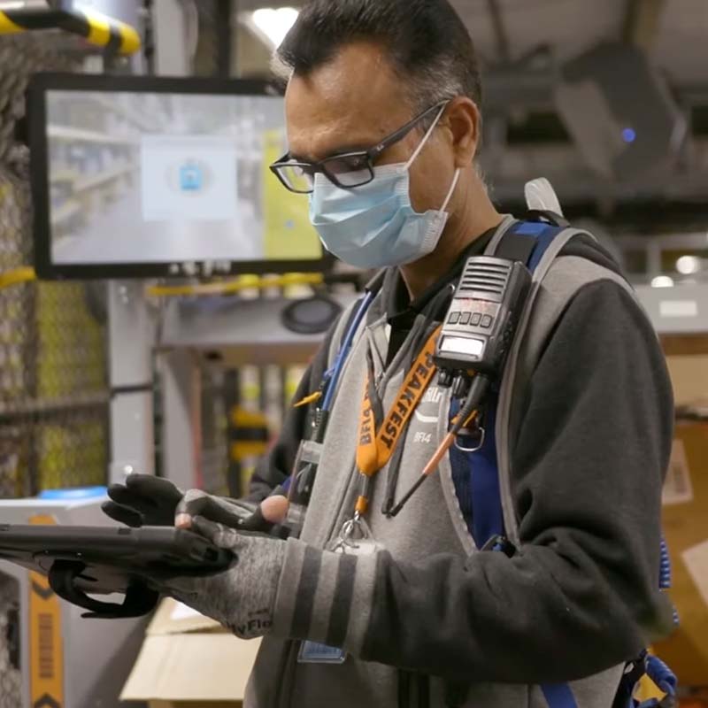 A warehouse worker looking at his informational pad