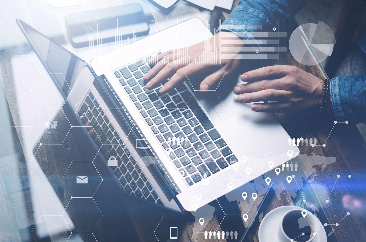 Hands typing on laptop with overlay of lock, email, people, and chart icons
