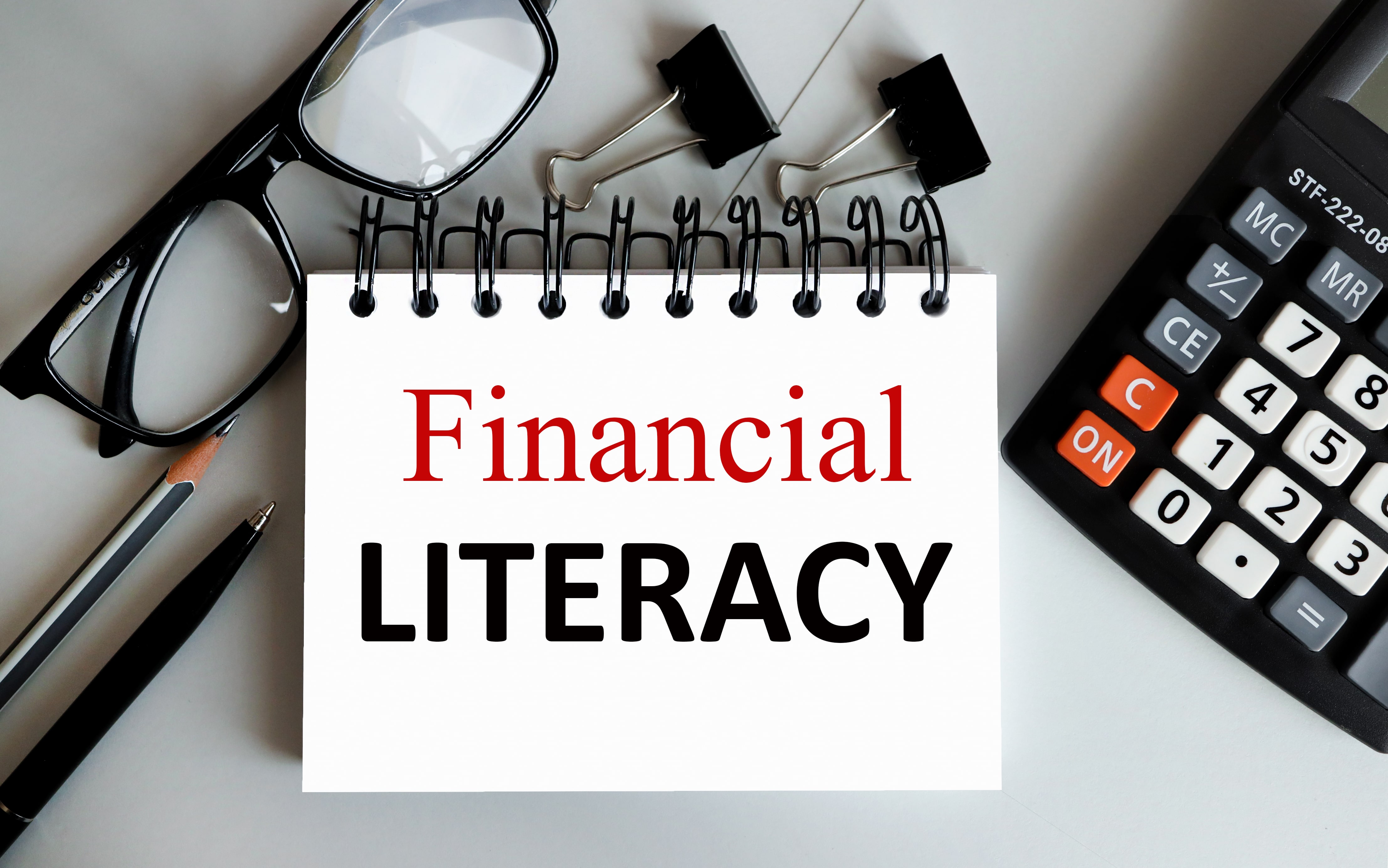 financial literacy, text on white paper on gray background