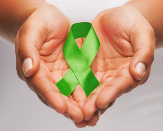 Two hands holding a green awareness ribbon