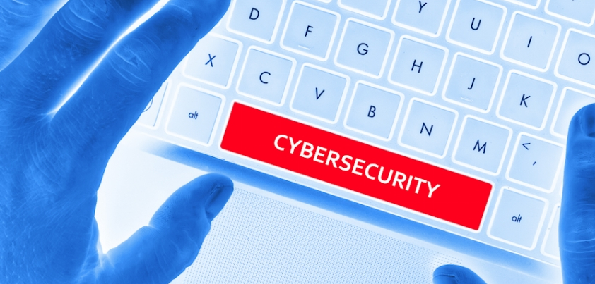 A set of hands over a keyboard with one of the keys saying 'cybersecurity'