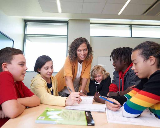 A teacher with her students around her.