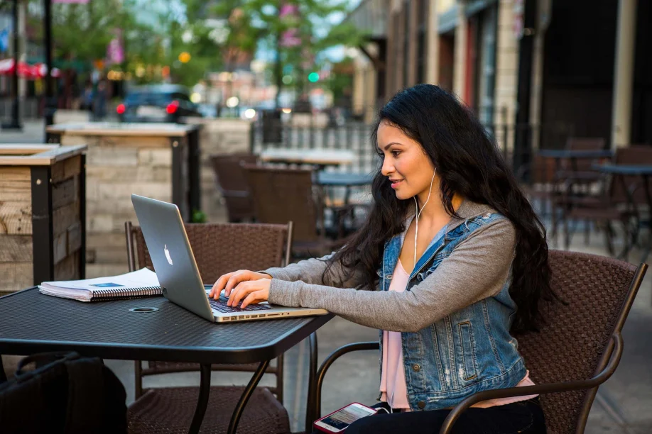 A woman outside on her laptop.