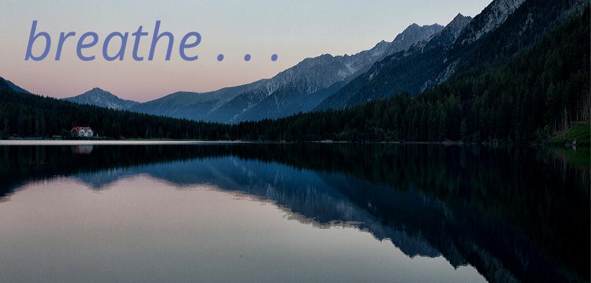 A scenic lake surrounded by mountains and the word 'breathe' superimposed.