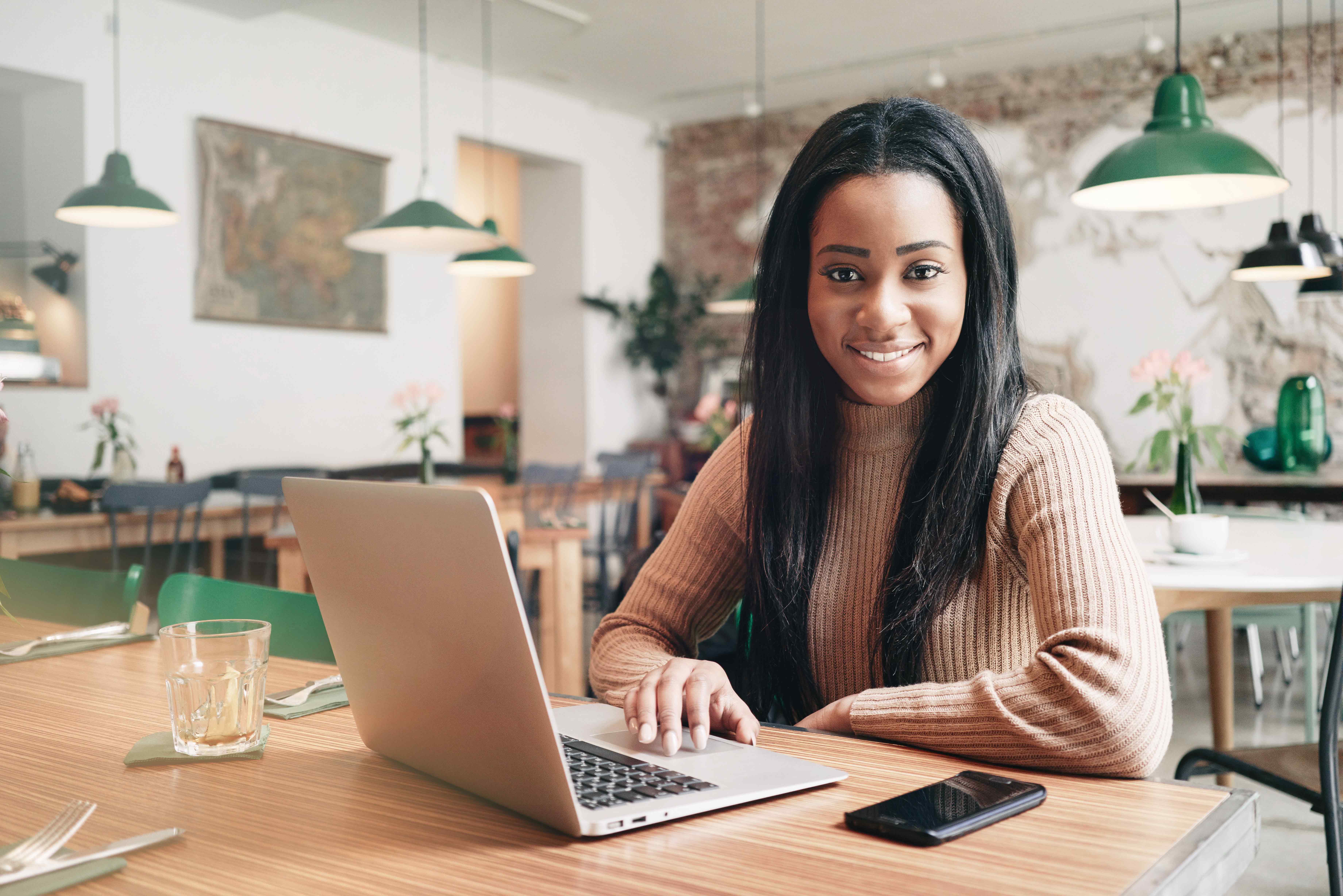 A woman at her laptop smiling.