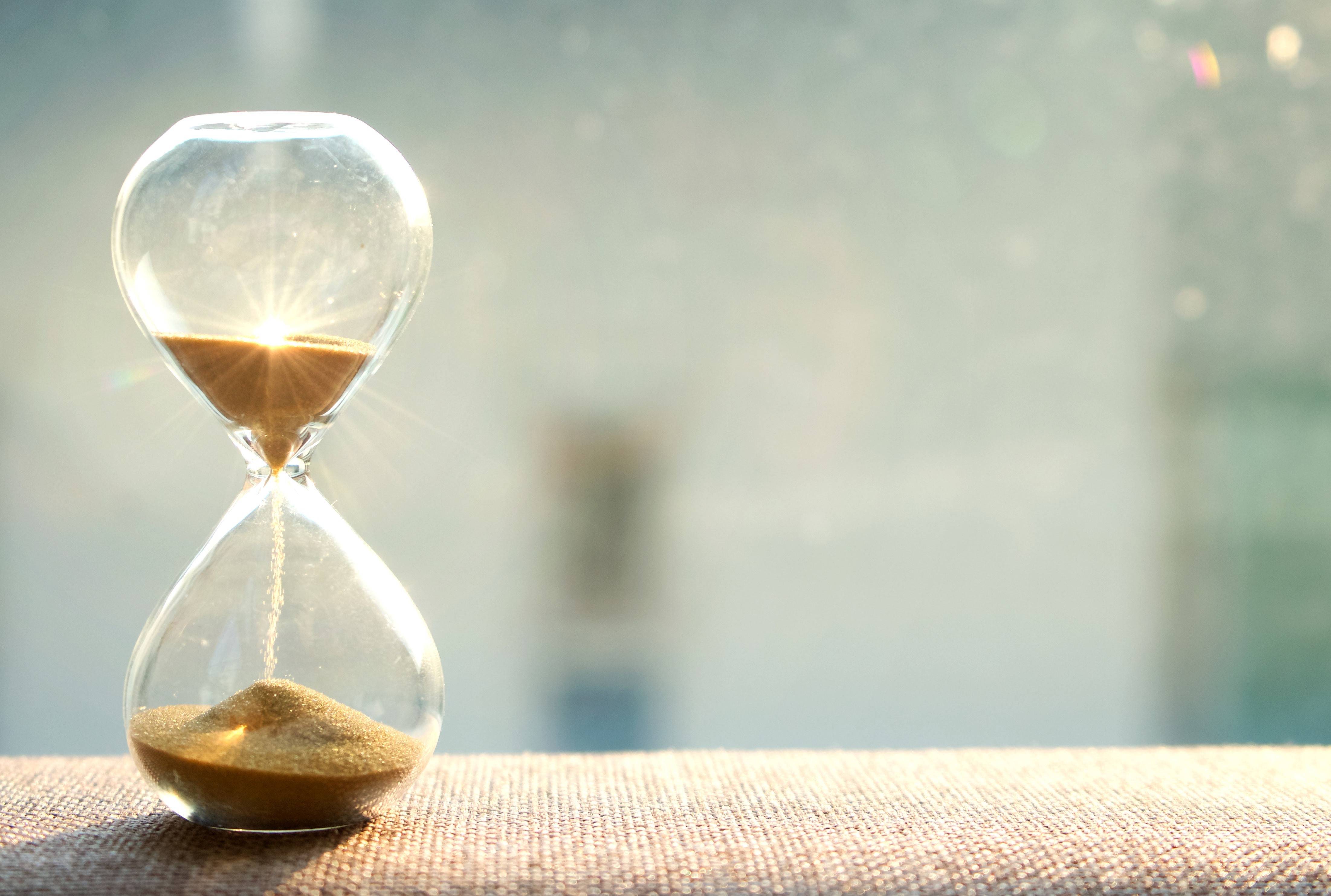 An hourglass with sand falling down through the neck.