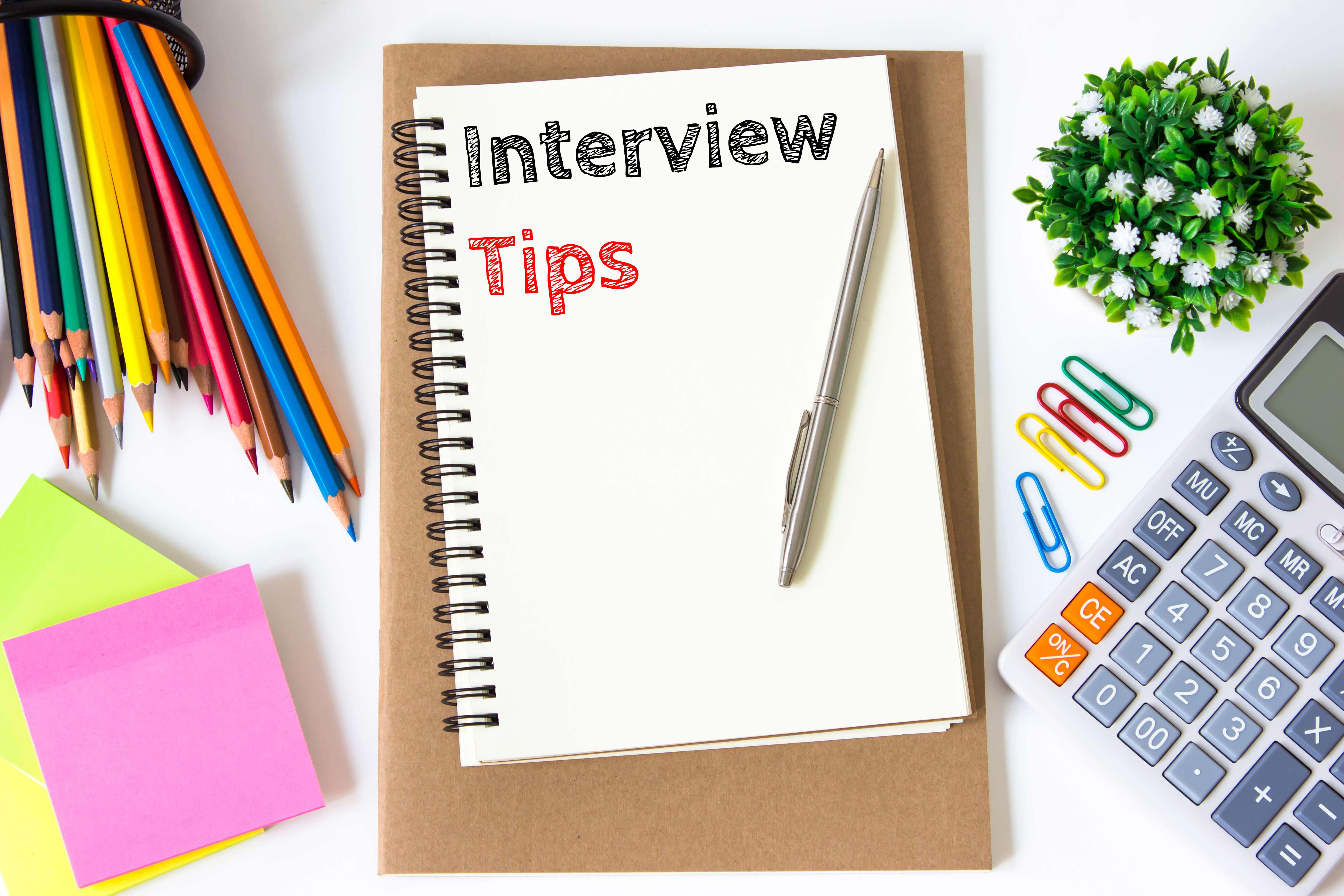 Desk utensils with 'Interview Tips' written on a piece of paper.