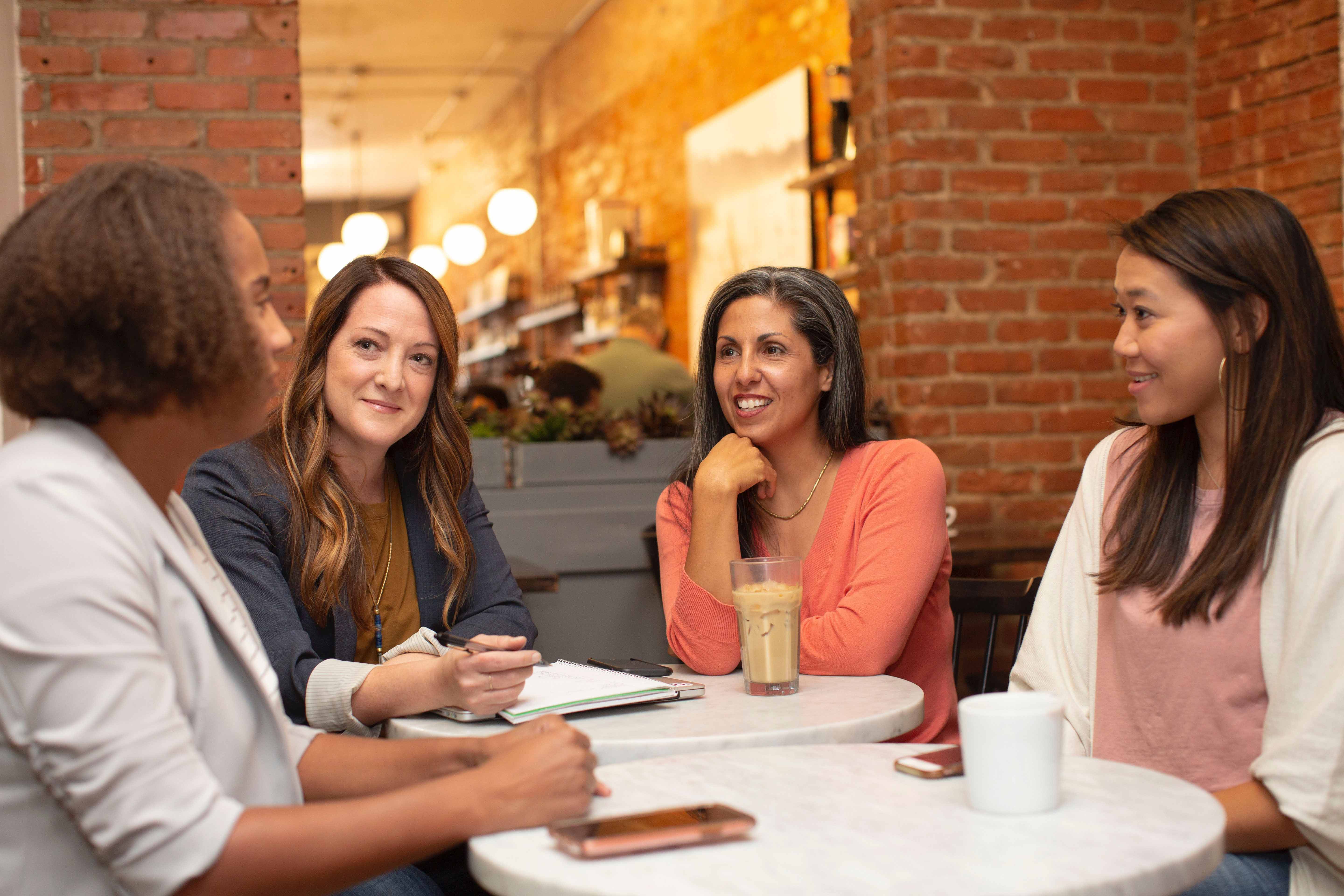 Four women having a meeting in a cafe.