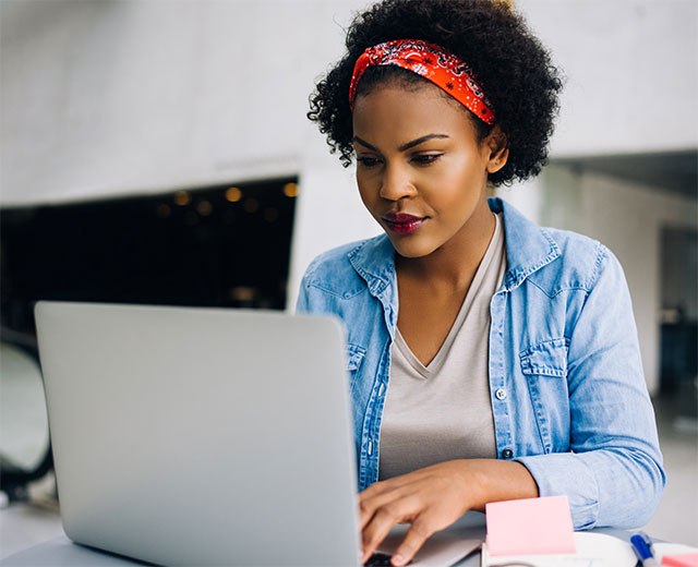 A woman sitting down at her laptop.