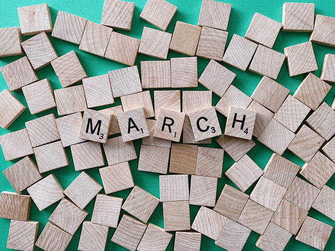 The word 'March' spelled out in scrabble tiles.