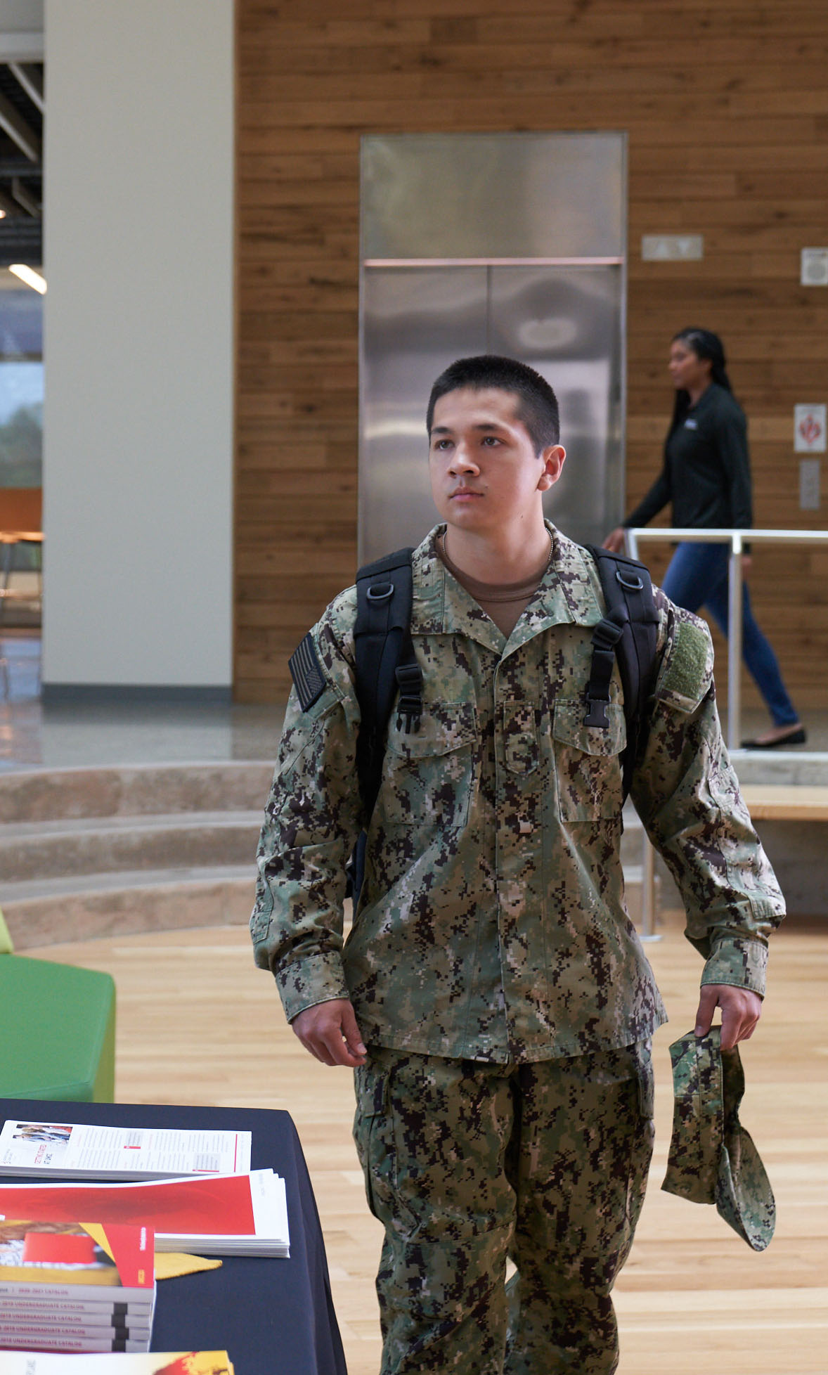 A person in uniform walking with a backpack.
