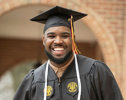 A man in his graduation cap and gown.