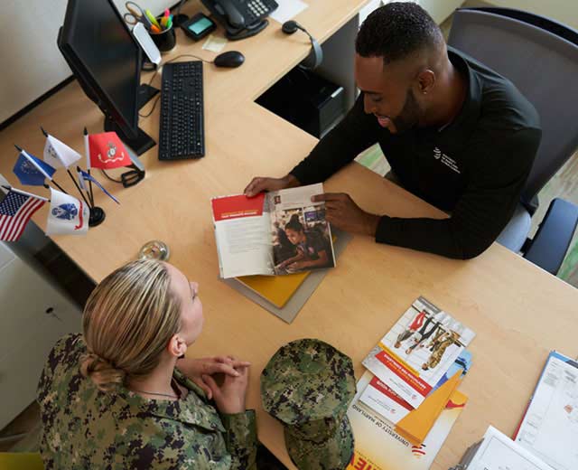 An Armed Forces servicemember talking with a UMGC guidance counselor.
