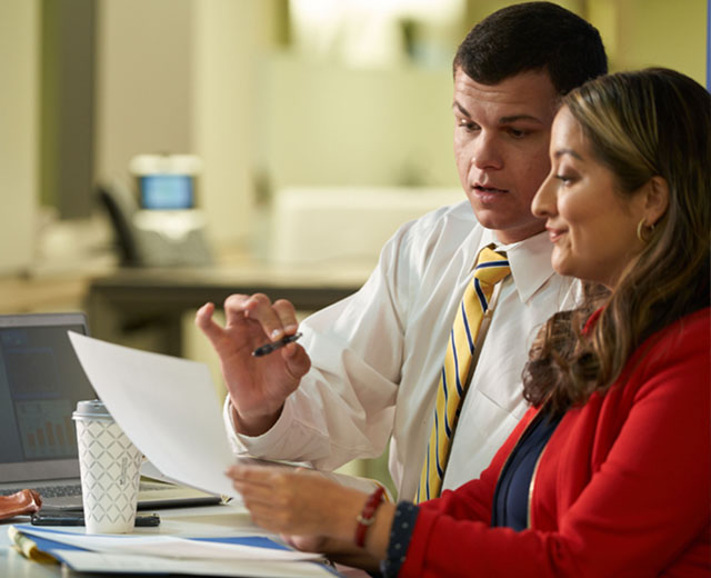 Two people looking at a piece of paper.