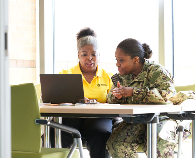 Two people looking at a laptop screen.