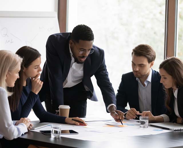 A group of people in business attire working at a table.