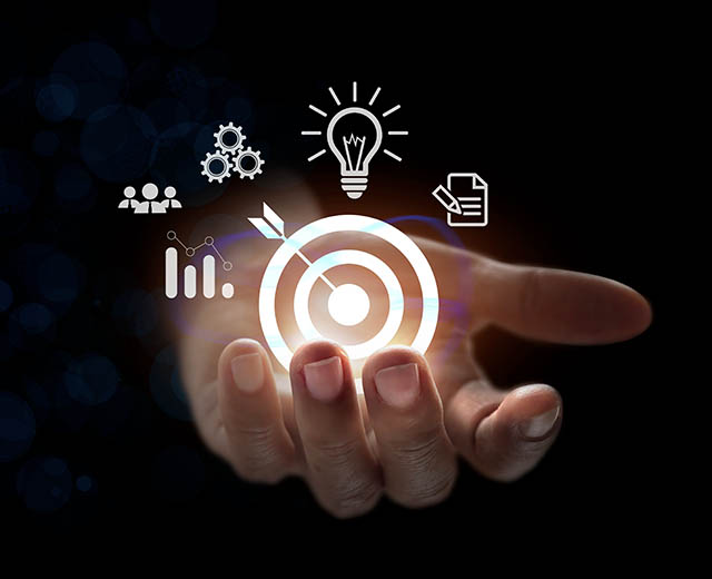 A hand holding abstract images of a bullseye, a lightbulb, and other icons.