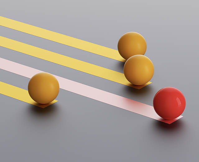 A red ball rolling ahead of three yellow balls.