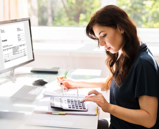 A person using a calculator at a desk.