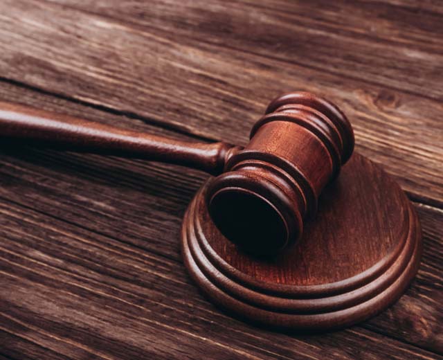 A wooden gavel on a wood table.