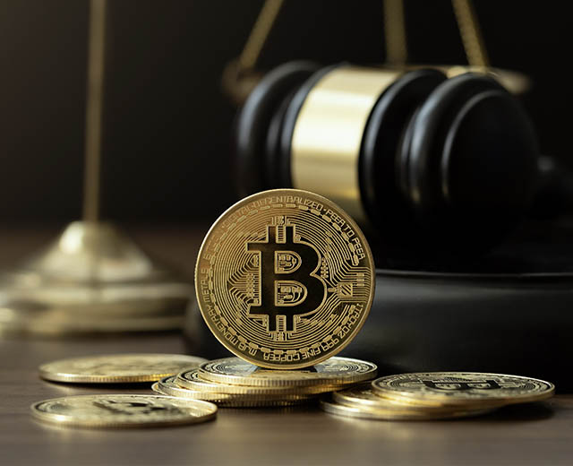 Bitcoins with a gavel and a scale in the background.