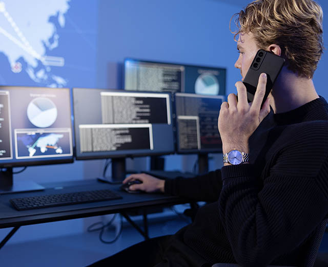 A person on a mobile phone looking at digital screens.