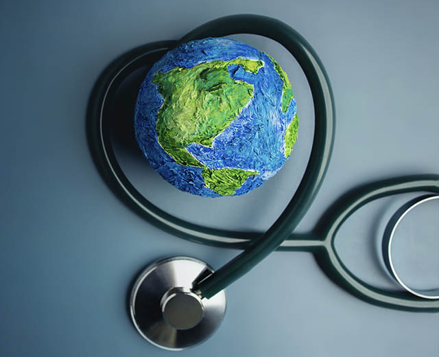 A stethoscope placed around a handmade globe.