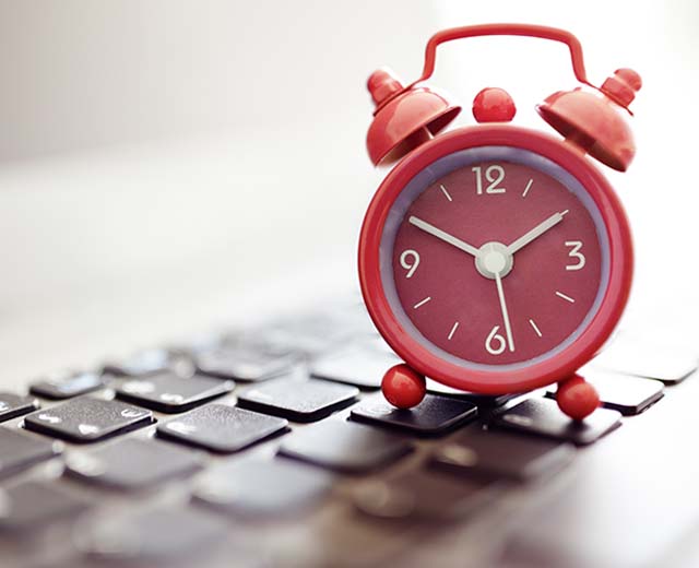 An alarm clock resting on a keyboard.