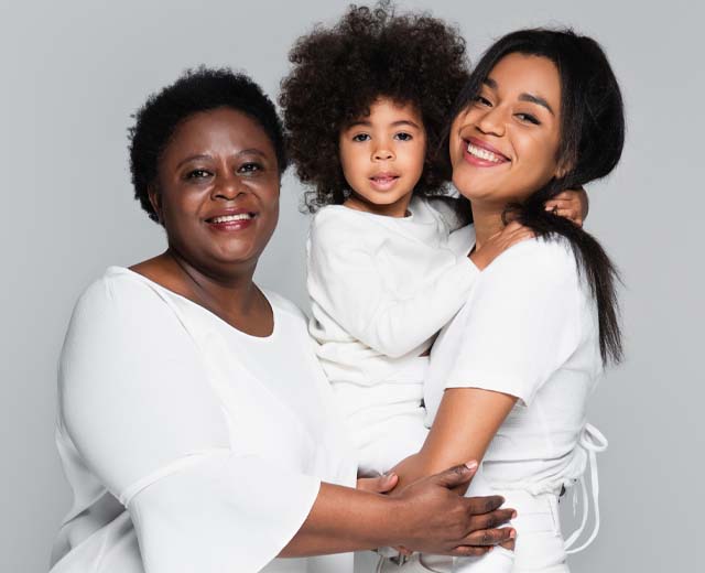 One adult and two children smiling for a group photo.